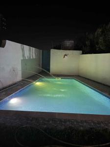 a swimming pool lit up at night with at Ridha in Djerba +2 photos