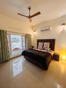 a bedroom with a bed and a ceiling fan at Kudrat Villa with Private Pool in Dehradun