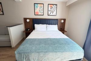 a bedroom with a large bed with a blue headboard at Wingate by Wyndham Athens GA in Athens