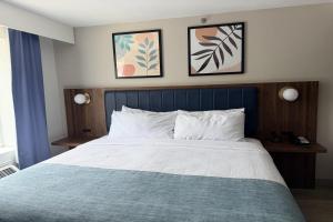 a bed in a bedroom with two pictures on the wall at Wingate by Wyndham Athens GA in Athens
