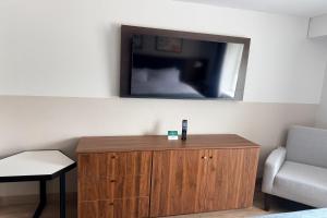 a room with a tv and a wooden cabinet at Wingate by Wyndham Athens GA in Athens +73 photos