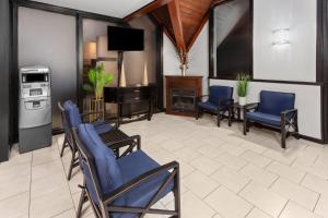 a living room with blue chairs and a fireplace at Travelodge by Wyndham Milwaukee in Milwaukee