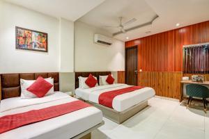 a hotel room with two beds and a desk at Hotel Sai Deluxe in New Delhi +34 photos