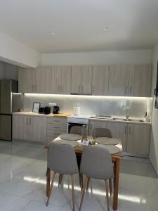 a kitchen with a wooden table and chairs and a counter at Eleonora apartment in Porto Rafti +7 photos