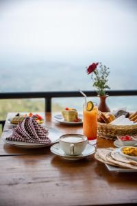 a wooden table with plates of food on it at Leisure Mount Villa in Haputale +59 photos