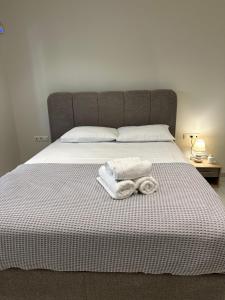 a bed with two towels and two pillows on it at Eleonora apartment in Porto Rafti