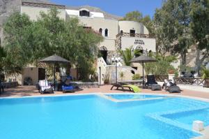 una grande piscina blu di fronte a un edificio di TheArtemis Perissa a Perissa