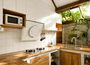 a kitchen with a sink and a microwave at Banyan Villa Panglao with private pool in Panglao Island