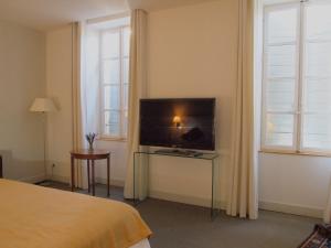 a bedroom with a bed and a television on a table at La Maison Saint Jean in Boulbon