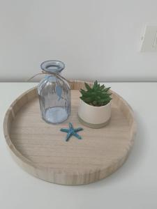 a round wooden tray with a glass jar and a plant at Vila MerSea in Mamaia Sat/Năvodari