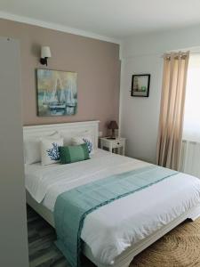 a bedroom with a large white bed with blue pillows at Vila MerSea in Mamaia Sat/Năvodari +18 photos
