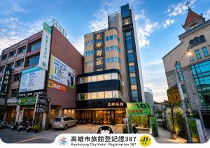 a large building with a clock tower in a city at Huaxiang Hotel - Zuoying in Kaohsiung