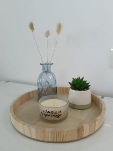 a vase and a candle on a wooden tray at Vila MerSea in Mamaia Sat/Năvodari