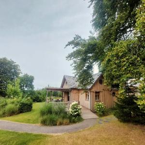 a wooden cabin in a garden with a walkway at Au Coq et fa gnes in Jalhay