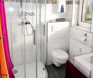 a white bathroom with a toilet and a shower at Carmen u. Rudolf Lutz in Norddeich +20 photos