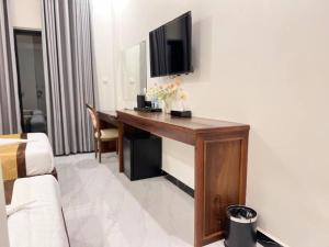 a room with a desk with a television on a wall at Meatophum Samnang in Battambang