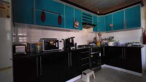 a kitchen with blue cabinets and a black counter top at "Sofia" Guest House-Hostel in Samarkand +98 photos