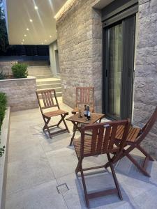 two chairs and a wooden table on a patio at Eleonora apartment in Porto Rafti