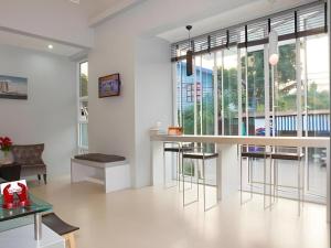 a living room with a bar and some windows at Soontree House Hotel in Udon Thani