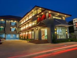 a large house with lights on in a street at Soontree House Hotel in Udon Thani