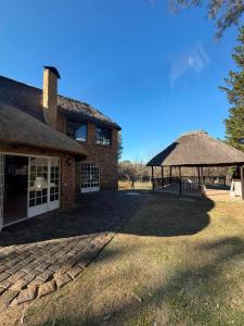 a large brick building with a thatch roof at The Blue Gum Collection in Midrand