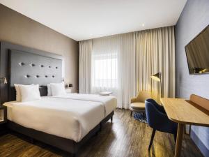 a hotel room with a bed and a desk at Mercure Hotel Amersfoort Centre in Amersfoort