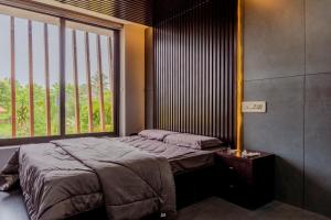 a bedroom with a bed and a large window at E7 Apartment in Bekal