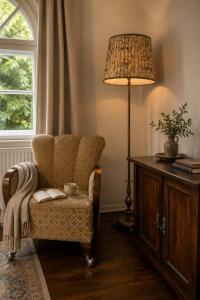 a living room with a chair and a lamp at HAUS 1926 Łagów Boutique Villa in Łagów