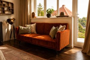 a brown couch in a living room with a window at HAUS 1926 Łagów Boutique Villa in Łagów