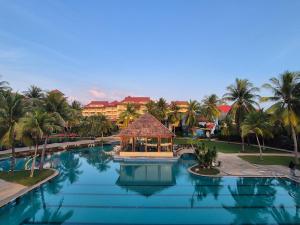 a resort swimming pool with a gazebo and palm trees at Sand & Sandals Desaru Beach Resort & Spa in Desaru