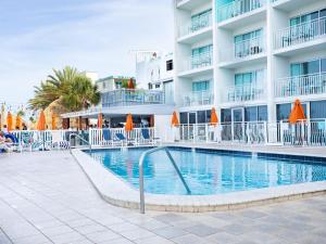 a swimming pool in front of a hotel at Dolphin Sands Clearwater Beach, an Ascend Collection Hotel in Clearwater Beach