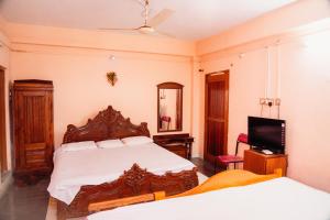 a bedroom with a bed and a tv in it at JS Homestay in Nāgercoil