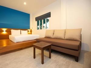 a living room with a couch and a bed at Thalassa Hotel in Ko Tao