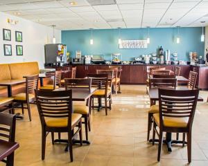 a restaurant with wooden tables and chairs and a counter at Sleep Inn & Suites Monticello in Charlottesville