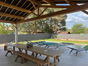 a patio with a table and chairs and a pool at Gîte du Grand Frêne in Nérac