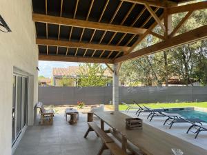 a patio with a table and chairs and a pool at Gîte du Grand Frêne in Nérac