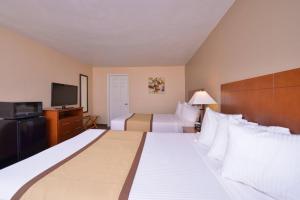 a hotel room with two beds and a flat screen tv at Quality Inn & Suites Williamsport in Williamsport