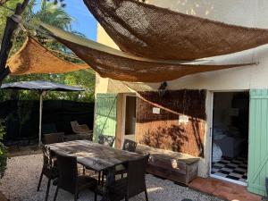 a patio with a table and chairs and an umbrella at Charming garden apartment Lorettes in Saint-Tropez