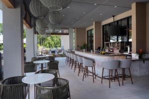 a restaurant with tables and chairs and a bar at Hyatt House Destin in Destin