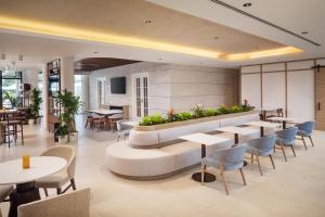 a restaurant with tables and chairs and a bench with plants at Hyatt House Destin in Destin