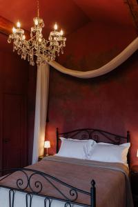 a bedroom with a bed with a chandelier at KISLOV Vineyard Boutique Hotel in Hagimus