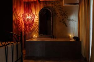 a bathroom with a tub and a mirror and candles at KISLOV Vineyard Boutique Hotel in Hagimus