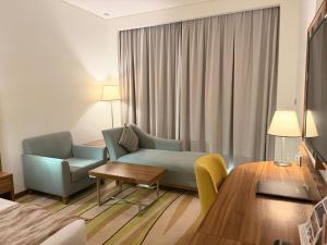 a hotel room with a couch and a table at Jacob's Garden Hotel in Dubai
