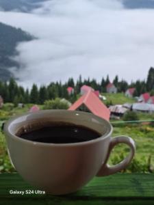 a cup of coffee sitting on top of a table at Gomis mta house in Itʼkhvisi