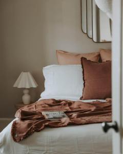 a bed with a brown blanket and pillows at Little Elizabeth in West Hobart