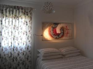 a bedroom with a bed with white sheets and a window at Casas DeCá & DeLá in Ponte de Lima