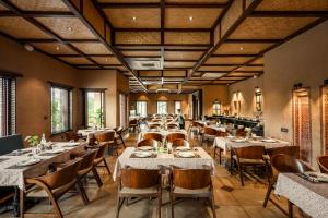 a dining room filled with tables and chairs at AamaGhati Wildlife Resort, Ranthambore in Sawāi Mādhopur