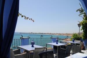 two tables and chairs with a view of the ocean at Hotel Palladio in Giardini Naxos