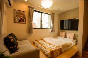 a bedroom with a bed and a couch in it at 和モダン福 名古屋駅徒歩8分 最大10名 一軒家貸切 寝室3 in Minami-sotoborichō