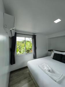 a bedroom with a white bed and a window at Siriwan boutique hotel in Ban Met Nang Chi
